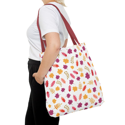 Person carrying the Autumn Leaves Tote Bag, featuring a vibrant leaf pattern and burgundy straps, ideal for everyday use with reinforced stitching and boxed corners for extra durability.