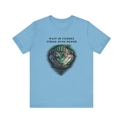 Crocodile: Walk in Silence, Strike with Purpose Bella+Canvas Unisex T-Shirt featuring a cartoon crocodile design, perfect for casual wear with a focus on quiet strength and unique style.