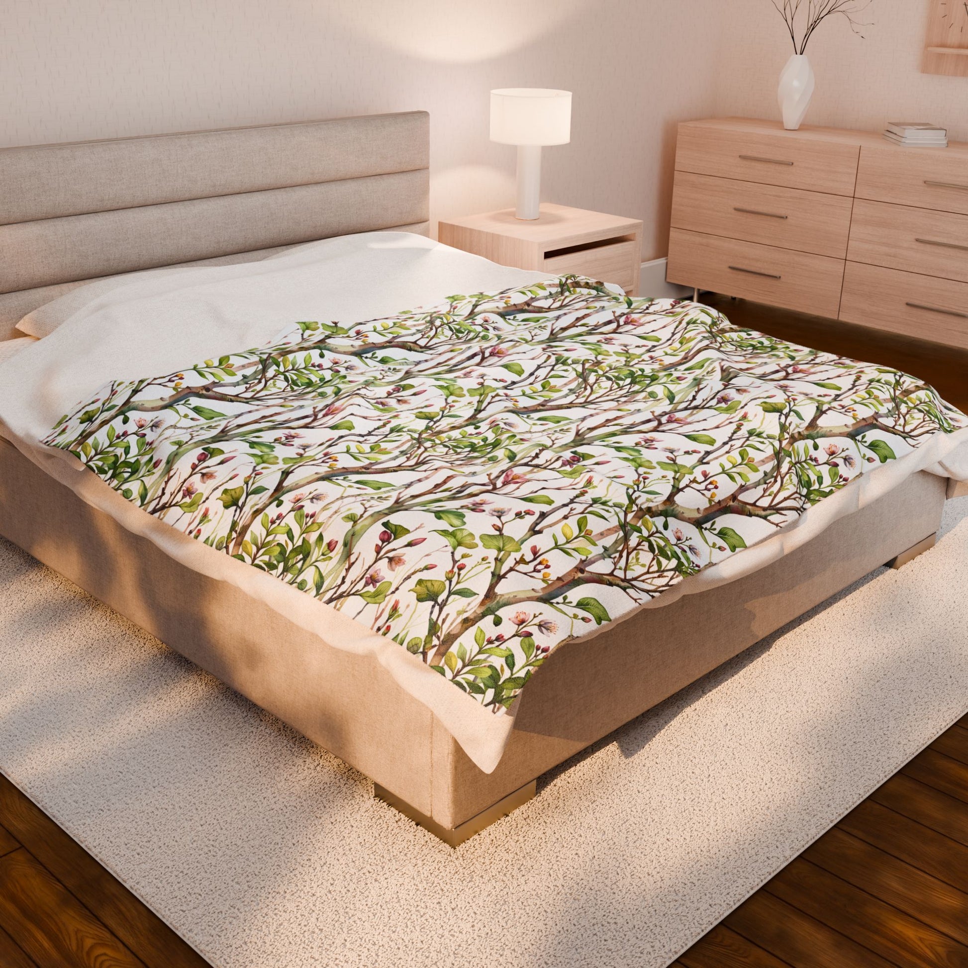 Plush Blanket - Blooming Forest Floor Design, featuring budding trees and flowers, draped over a bed with a dresser and lamp nearby, embodying FireBrook Essentials' cozy and uplifting style.
