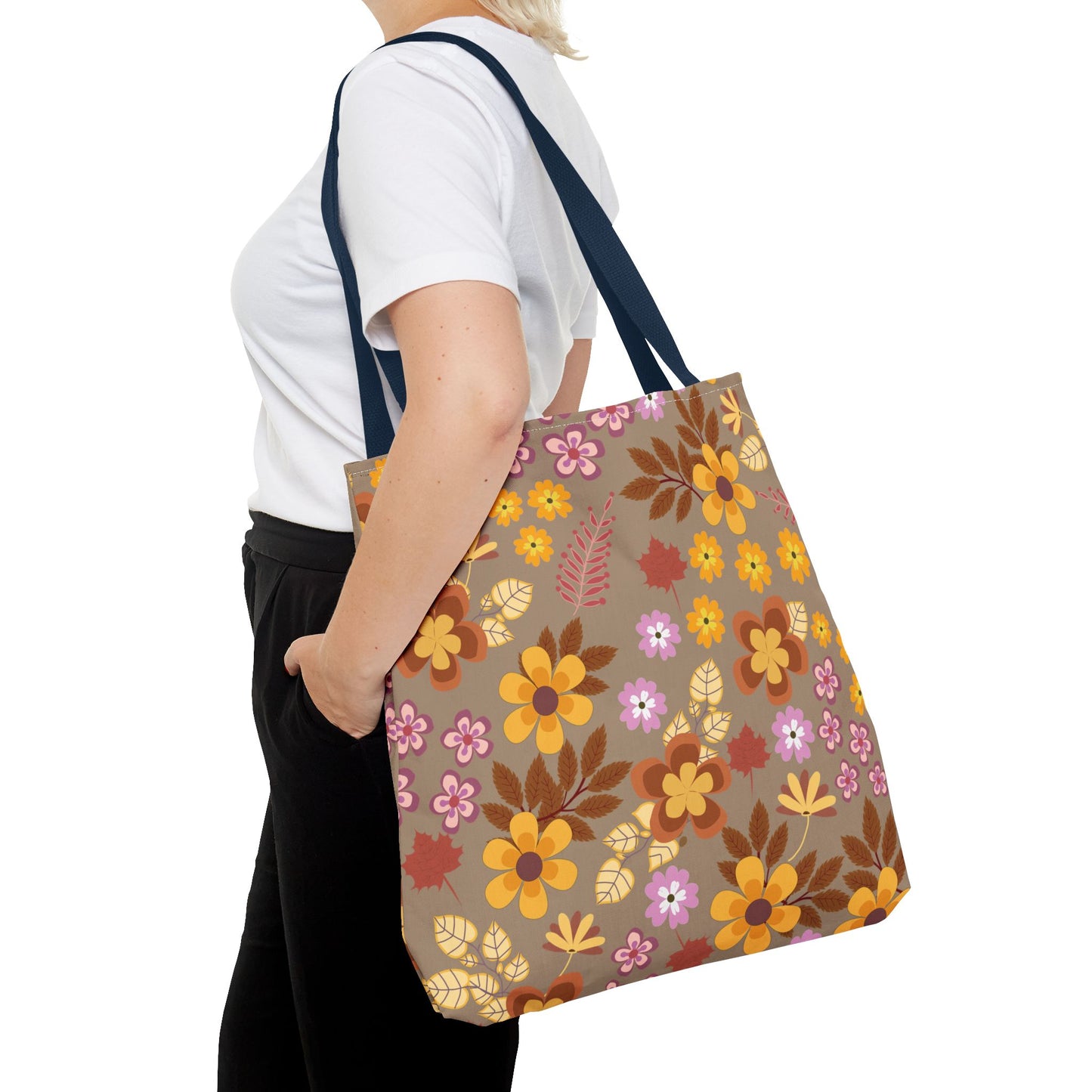 Person wearing a plain white T-shirt and black pants carries the Harvest Brown Bloom Tote Bag, adorned with warm-toned floral patterns, showcasing FireBrook Designs' blend of style and functionality.