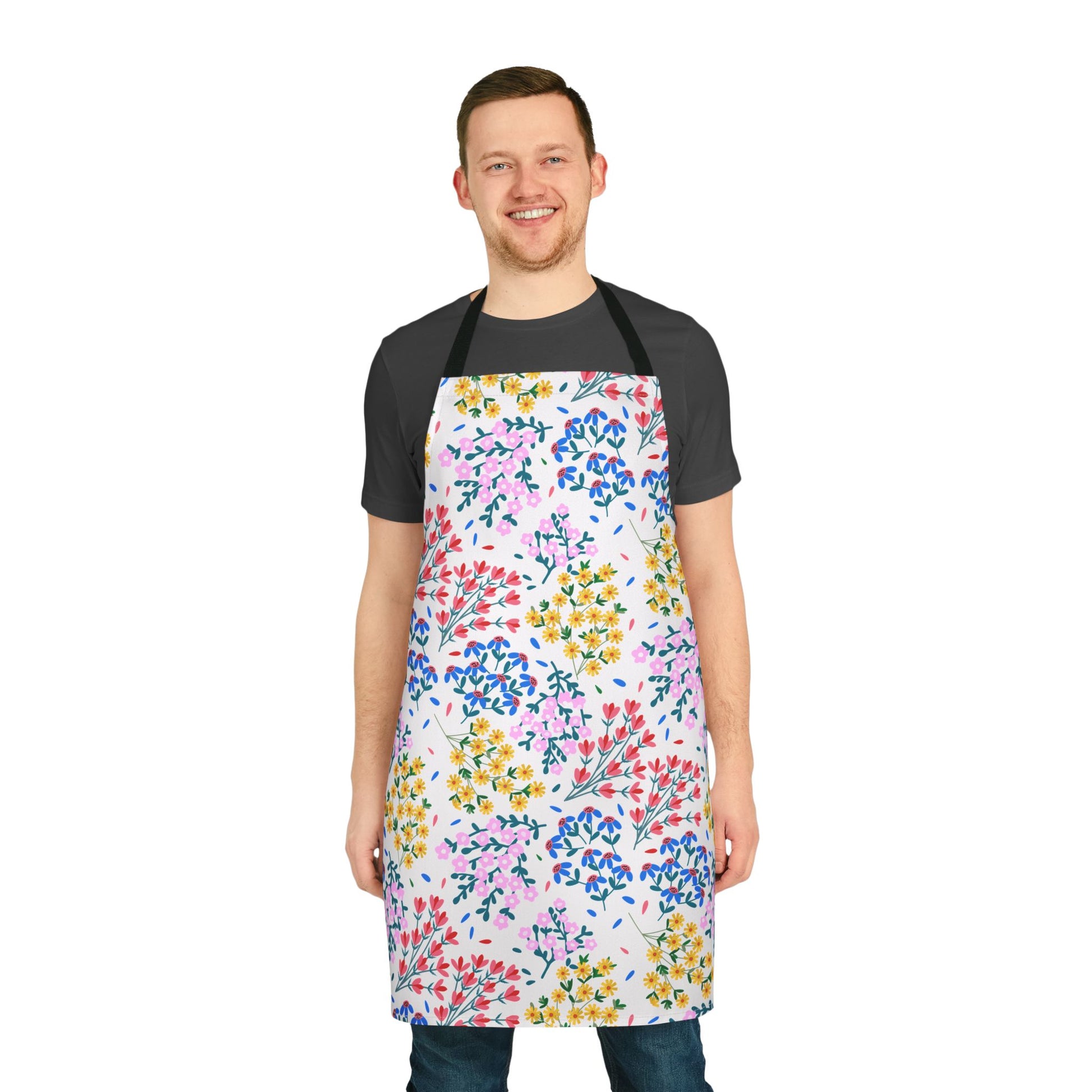 Smiling man wearing FireBrook Essentials' Floral Apron, featuring vibrant blooms on a white background, highlighting its comfort and style. Ideal for various activities, it embodies joyful, practical design.