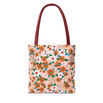 Floral Tote Bag with maroon straps features a vibrant floral pattern of orange, white, and rust flowers on pale pink. Ideal for summer, it's durable with reinforced stitching and boxed corners.
