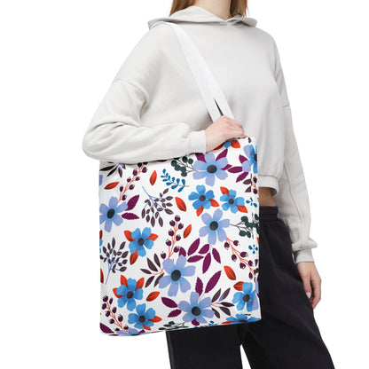 Floral Tote Bag with a vibrant blue, purple, and red graphic pattern, perfect for summer outings. The person carries it over their shoulder, showcasing its spacious design and sturdy white straps.