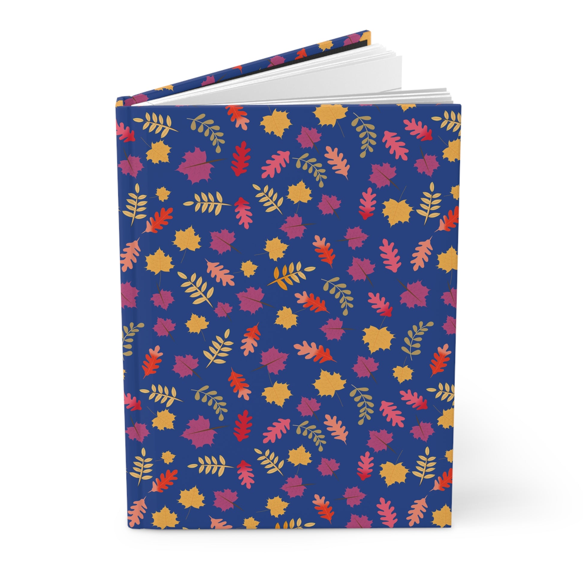 HARDCOVER JOURNAL, MATTE, RULED, 5X7, SEWN BIND, CLEAN-TEAR PAGES – FALL FOLIAGE, featuring a deep-blue cover adorned with vibrant autumn leaves, standing upright with pages fanned slightly open.