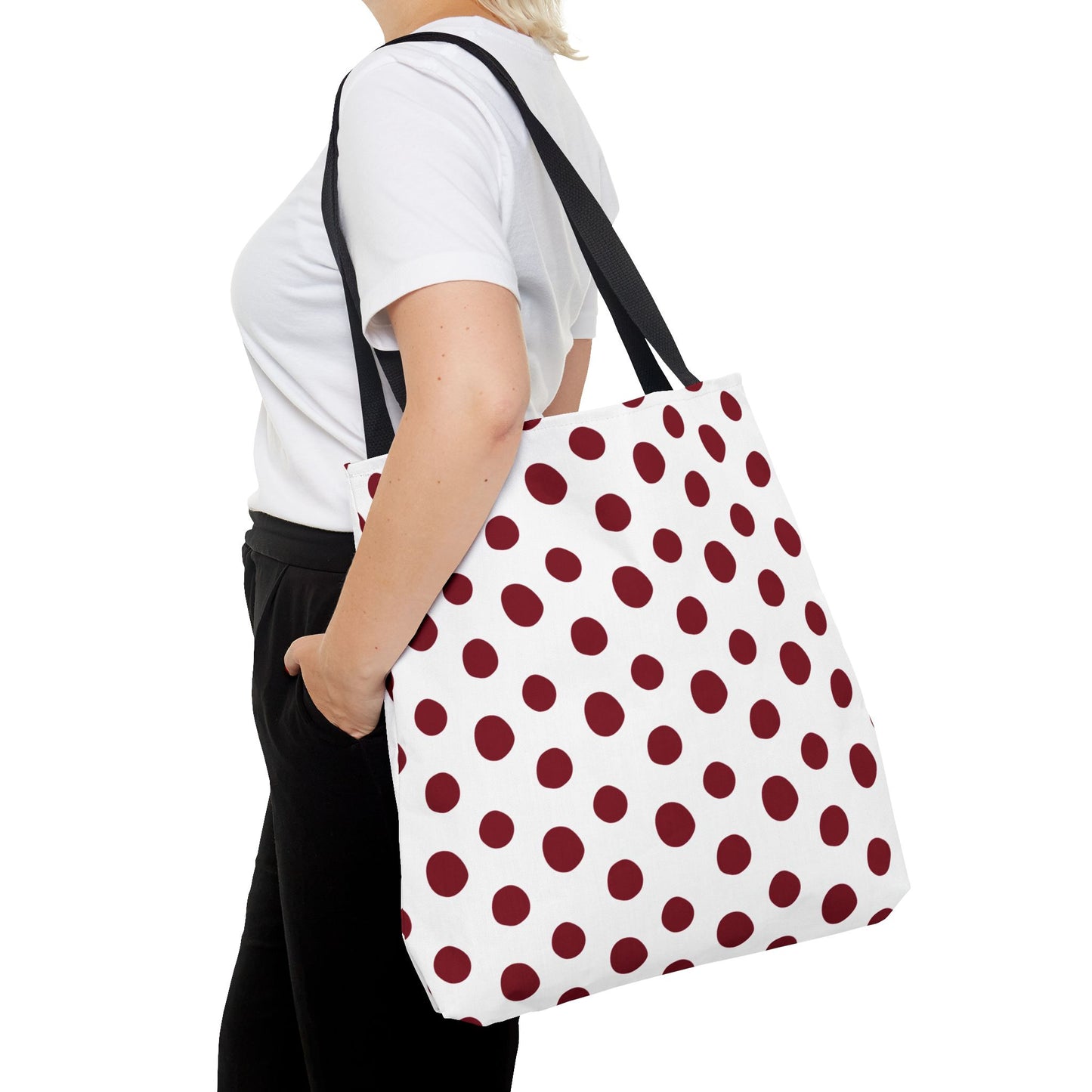 Woman holding Burgundy Polka Dots Tote Bag, featuring a white background with red polka dots and reinforced handles. This stylish, durable tote from FireBrook Designs embodies practicality and joy for everyday use.