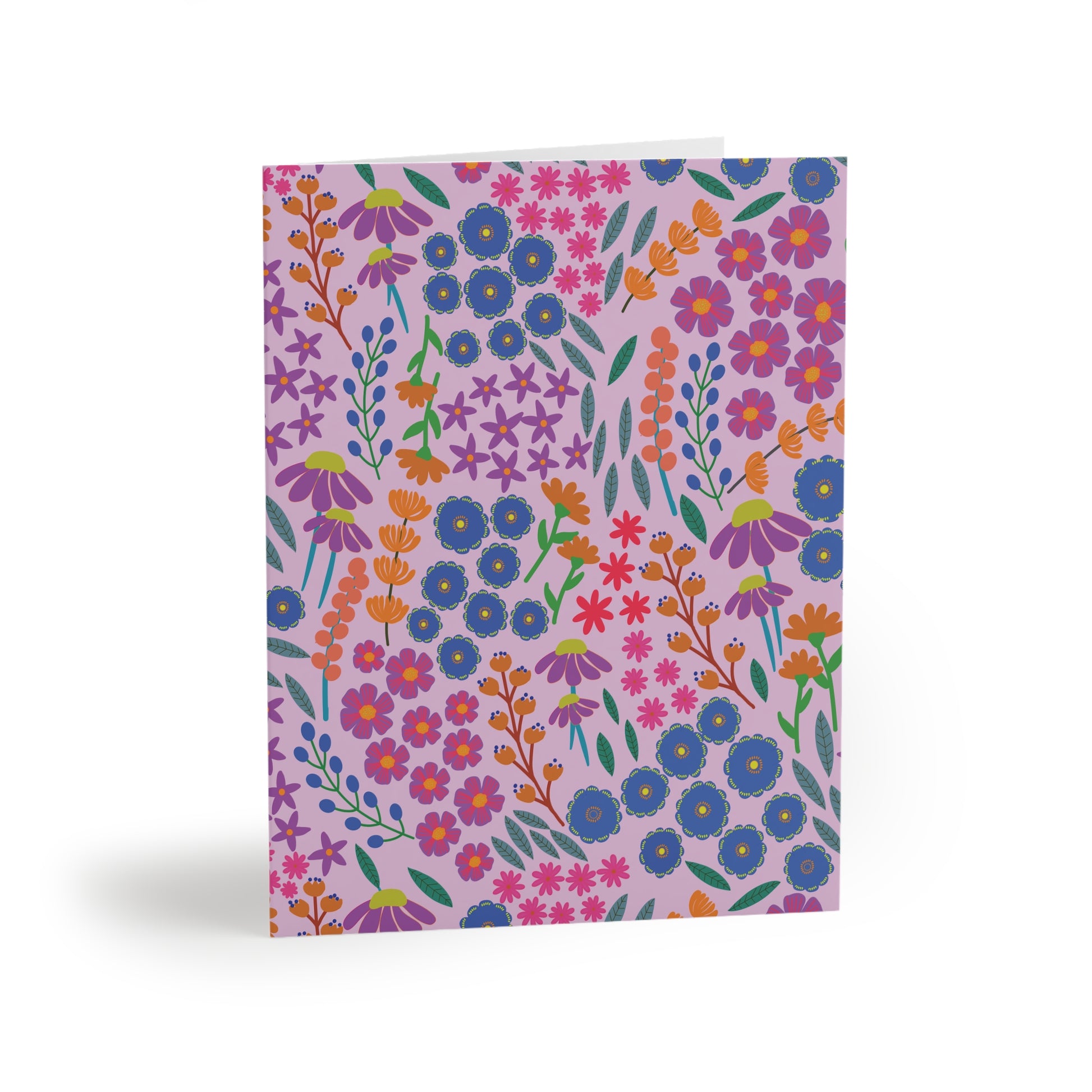 Floral Greeting Cards — Pack of 8/16/24, featuring a vibrant, stylized floral pattern on a lavender background, shown standing upright. Ideal for sending thoughtful messages, each card includes a matching white envelope.