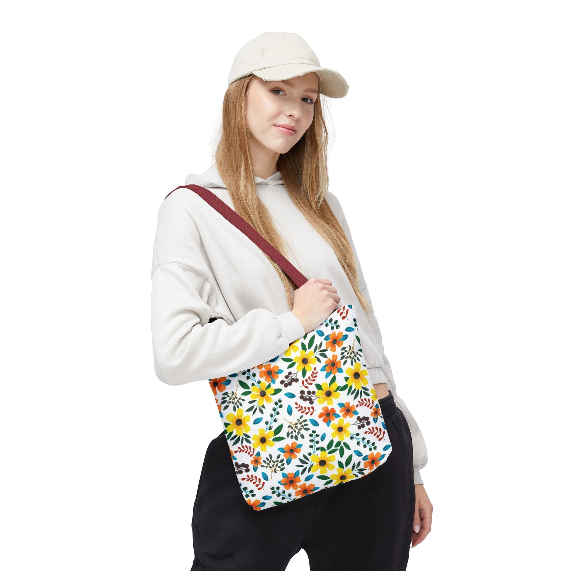 Floral Tote Bag with bright yellow and orange flowers, green leaves, and maroon strap, carried by a casually dressed woman adds a cheerful touch for summer outings or beach trips.