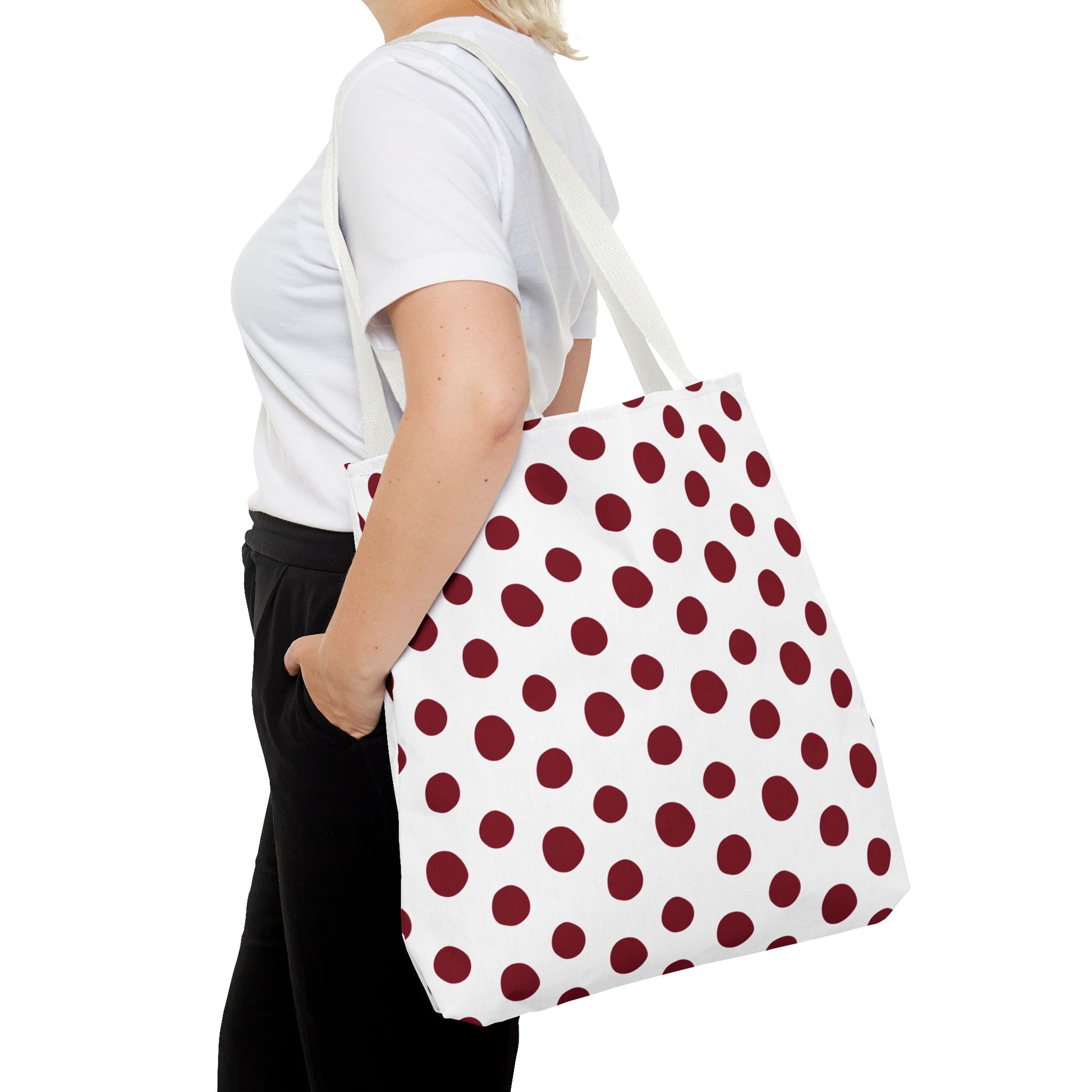 Burgundy Polka Dots Tote Bag held by a woman, showcasing its stylish red and white polka dot pattern. Perfect for everyday use, this durable design reflects FireBrook Essentials' commitment to joyful, practical fashion.