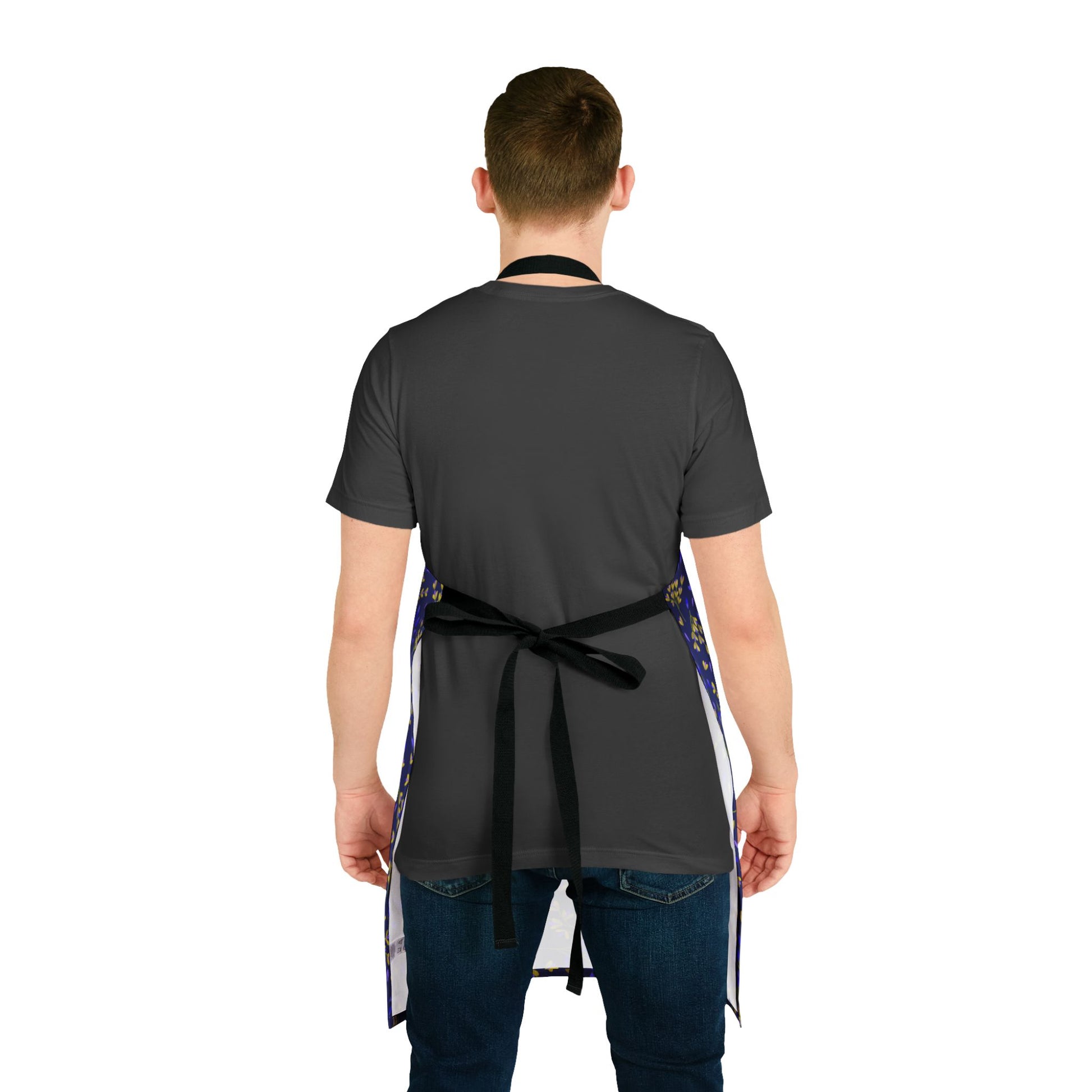 Floral Apron: Back view of a person wearing a dark-gray T-shirt, blue jeans, and a bib-style apron with black tie-back straps, featuring blue side panels with a light pattern, from FireBrook Designs.