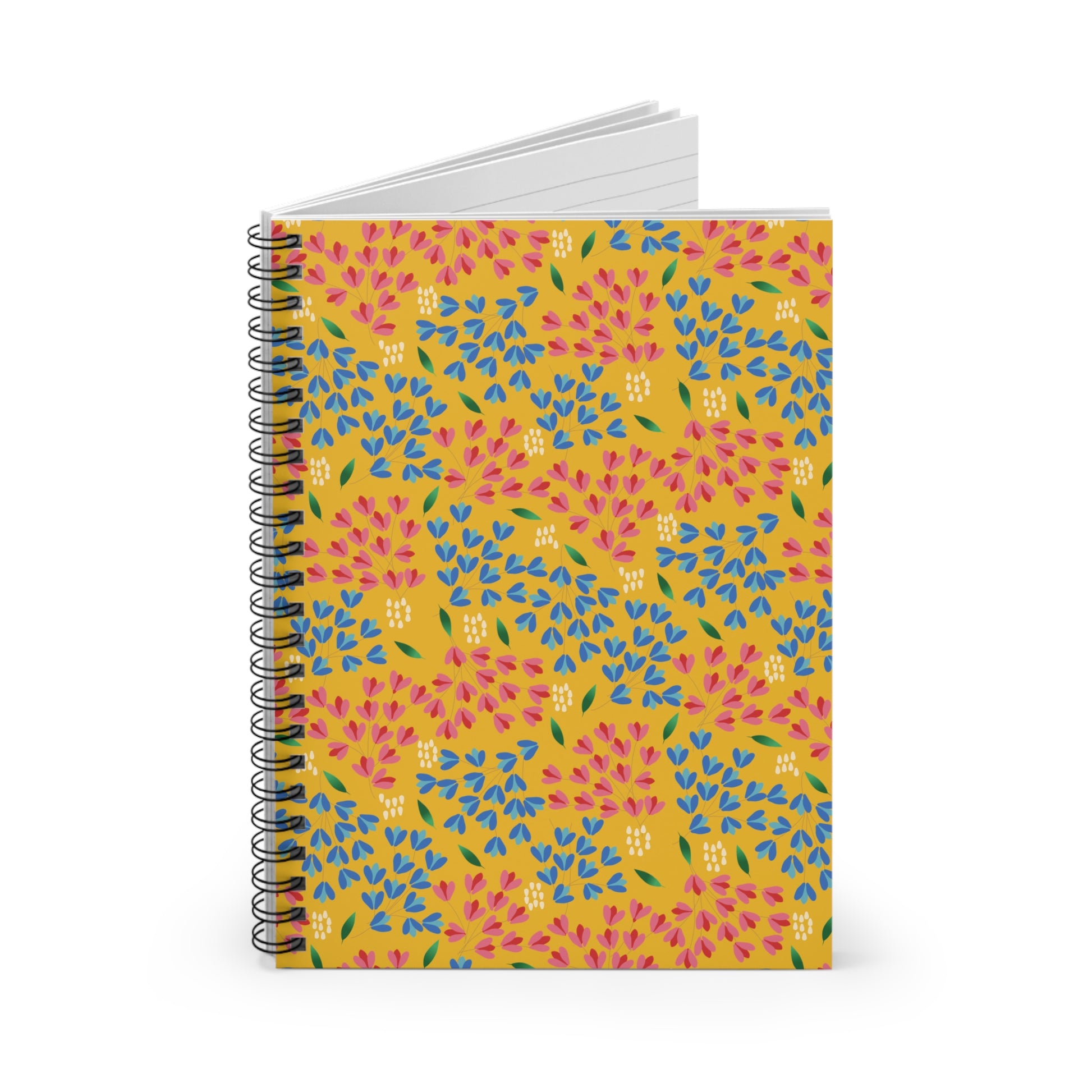 Floral Spiral Notebook with a vibrant mustard-yellow cover featuring a pink, blue, and green floral motif, standing upright. Its open pages reveal lined paper, perfect for creative note-taking or journaling.