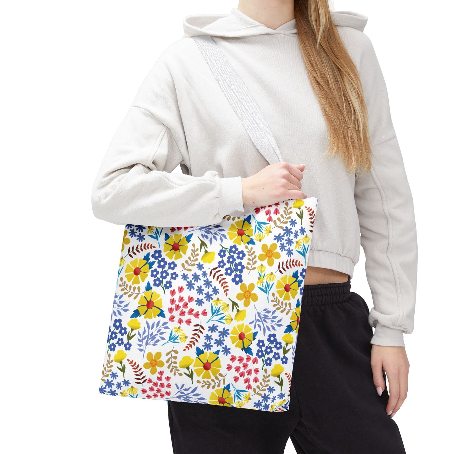 Floral Tote Bag with a vibrant multicolored floral pattern, held by a casually-dressed person. Ideal for summer outings, showcasing FireBrook Designs' ethos of stylish, joyful essentials.