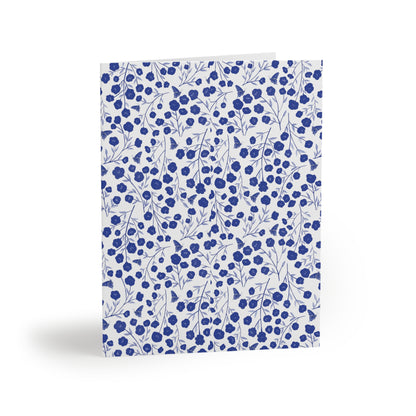 Floral Greeting Cards — Pack of 8/16/24 features a dense pattern of blue flowers and butterfly silhouettes on a white matte background, folded upright, embodying FireBrook Designs' uplifting and joyful style.