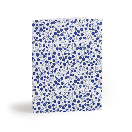 Floral Greeting Cards — Pack of 8/16/24 features a dense pattern of blue flowers and butterfly silhouettes on a white matte background, folded upright, embodying FireBrook Designs' uplifting and joyful style.