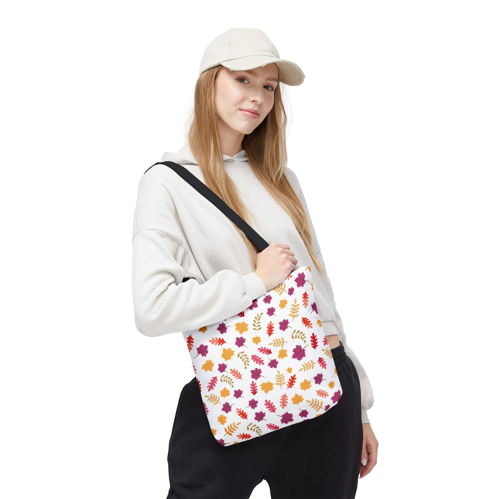 Young woman in casual attire models the Autumn Leaves Tote Bag, featuring a vibrant leaf pattern, showcasing its spacious, durable design ideal for daily use, embodying FireBrook Essentials' commitment to style and functionality.