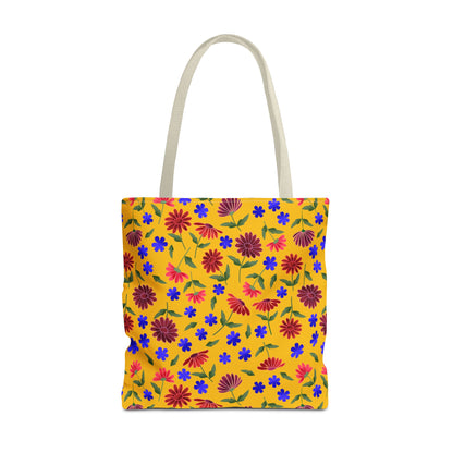 Golden Wildflower Tote Bag features a bright yellow base adorned with red and magenta daisies, small cobalt-blue flowers, and green leaves, complemented by natural-colored handles, embodying FireBrook Designs' joyful and practical style.