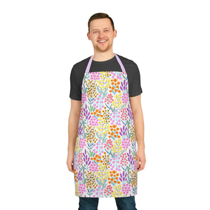 Smiling young man models FireBrook Designs' Floral Apron, showcasing vibrant blossoms on a stain-free, comfortable polyester canvas with a lavender neck strap, perfect for joyful cooking or crafting activities.