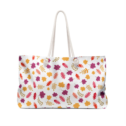 Weekender Bag with rope handles features a vibrant autumn-leaf pattern on white, ideal for stylish travel. Designed by FireBrook Essentials, it combines functionality and joy in a spacious, chic tote.