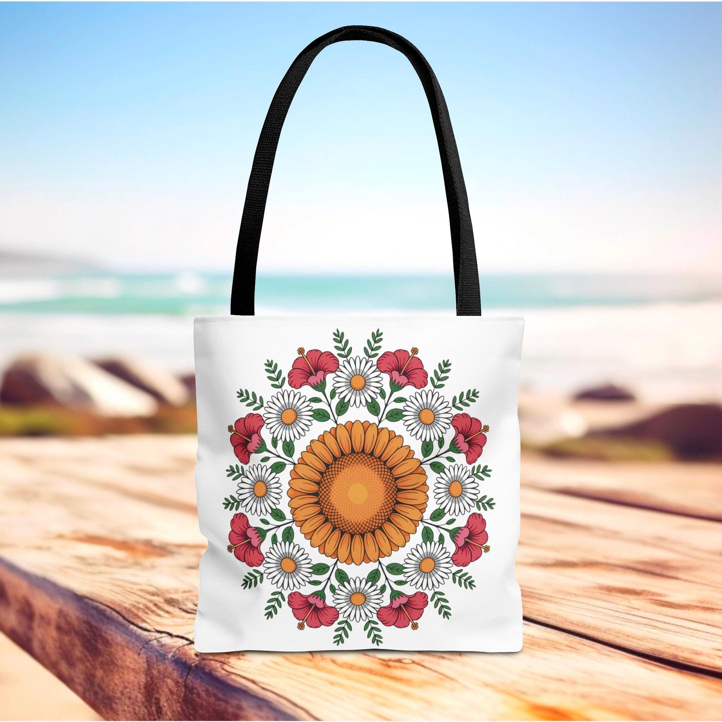 Mandala Sunflowers & Daisies Tote Bag featuring a detailed floral mandala design with sunflowers, daisies, and hibiscus, displayed on a wooden surface. Ideal for summer outings, reflecting boho-chic style.