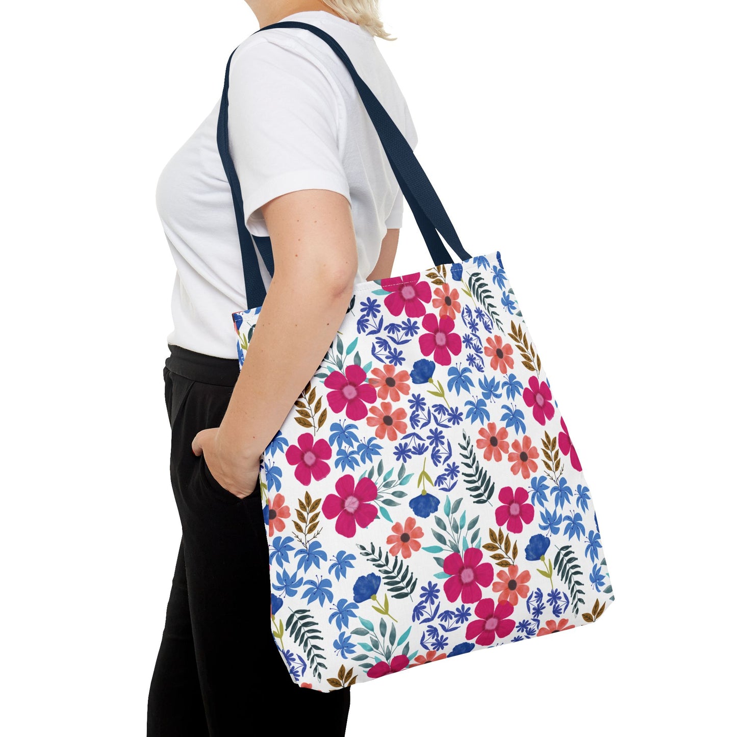 Confetti Wildflower Tote Bag with blue straps, featuring vibrant watercolor floral patterns, worn over shoulder. Ideal for bright, cheerful summer outings; embodies FireBrook Designs' uplifting, practical style.