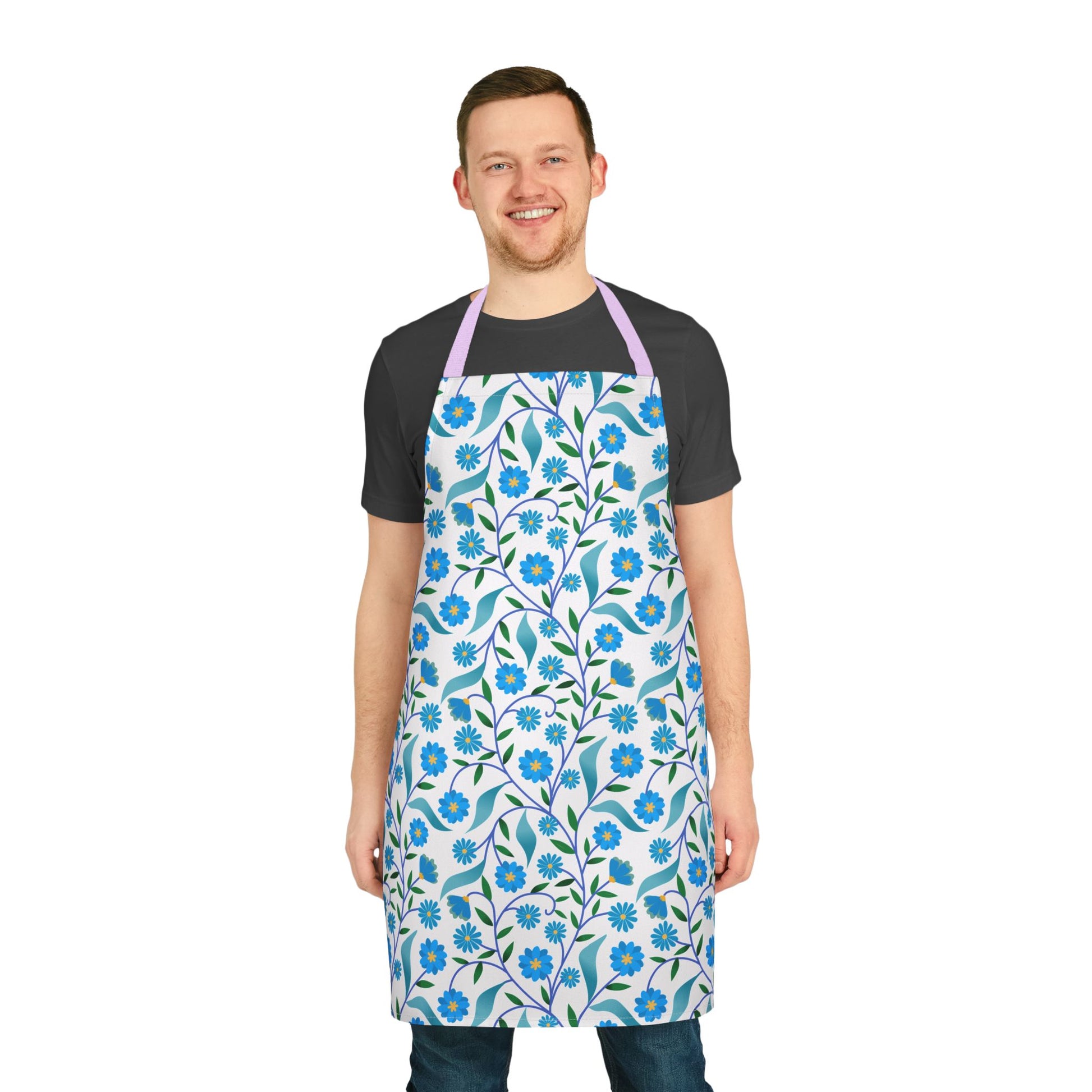 Man wearing Apron Floral Design with light-blue blossoms and green leaves over a black T-shirt and jeans, showcasing FireBrook Designs' stylish, stain-free, and comfortable polyester canvas apron for versatile use.