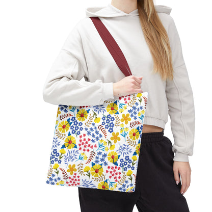 Floral Tote Bag with a vibrant, colorful blossom pattern and burgundy strap, ideal for summer outings. Seen carried by a person in casual attire, showcasing its cheerful design and spaciousness.