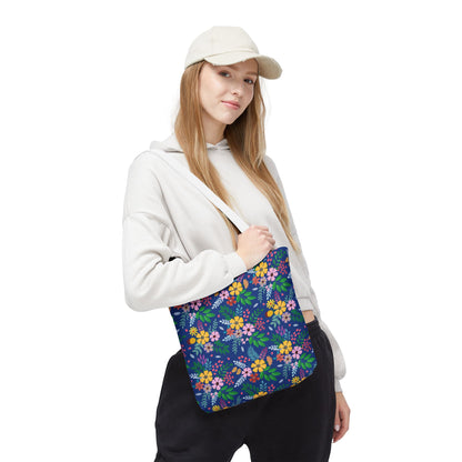 Floral Tote Bag with vibrant blossoms and foliage on dark blue, slung over a young woman's shoulder. Perfect for summer outings, embodying FireBrook Designs' joyful and uplifting style.
