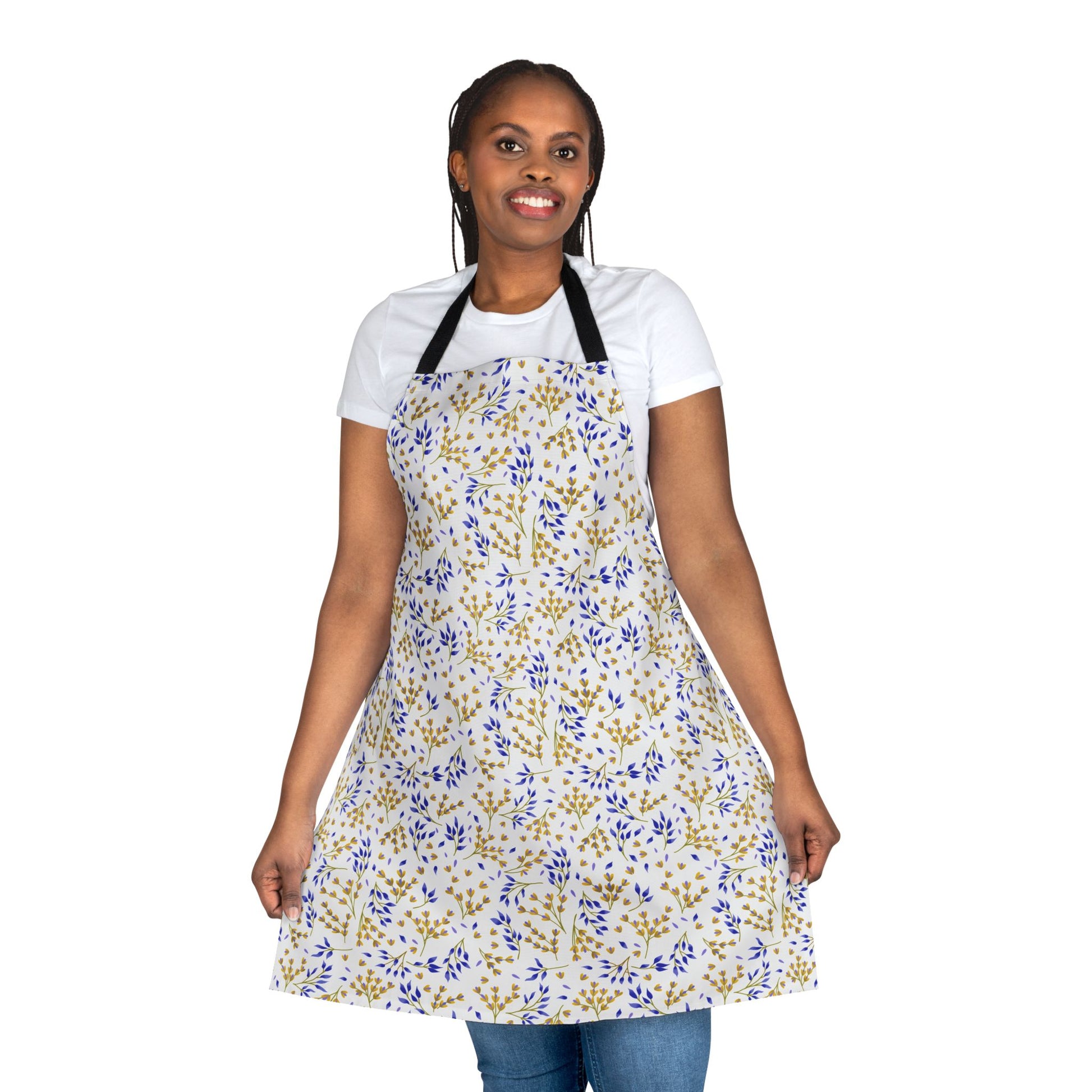 Person wearing the Floral Apron with blue and gold botanical print, showcasing its full shape against a plain background. The apron features a black neck strap, complementing a casual, stylish look.