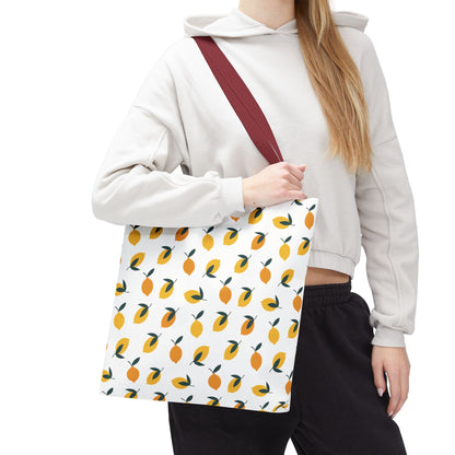 A person carries the Lemon Drop Toss Tote Bag, showcasing its burgundy-red strap and vibrant lemon pattern, embodying FireBrook Essentials' cheerful and stylish design ethos for joyful everyday use.