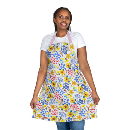 Person wearing the Apron Floral Design with vibrant floral patterns over a white T-shirt and blue jeans, smiling and holding the apron sides, highlighting its comfort and style from FireBrook Essentials.