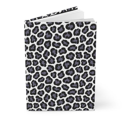 HARDCOVER JOURNAL, MATTE, RULED, 5X7, SEWN BIND, CLEAN-TEAR PAGES – LEOPARD: A stylish black-and-gray leopard spot cover on white, slightly open, revealing blank pages within.