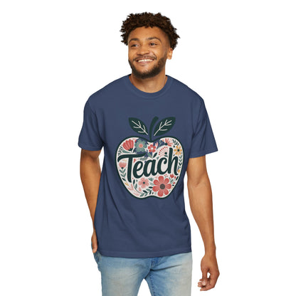 Floral Apple TEACH T-shirt features a hand-drawn apple with pastel florals and TEACH overlay, embodying FireBrook Essentials' uplifting, stylish approach for educators and nature lovers.