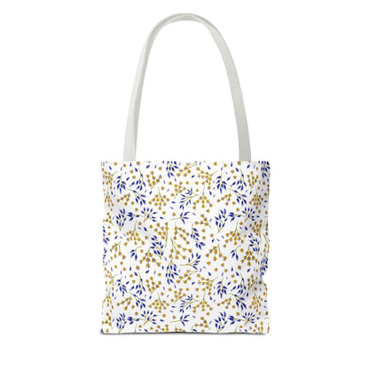 Wild Herb Garden Tote Bag features a white canvas body adorned with a golden-yellow and deep blue botanical sprigs pattern, offering a vibrant, durable option for summer outings or beach trips.
