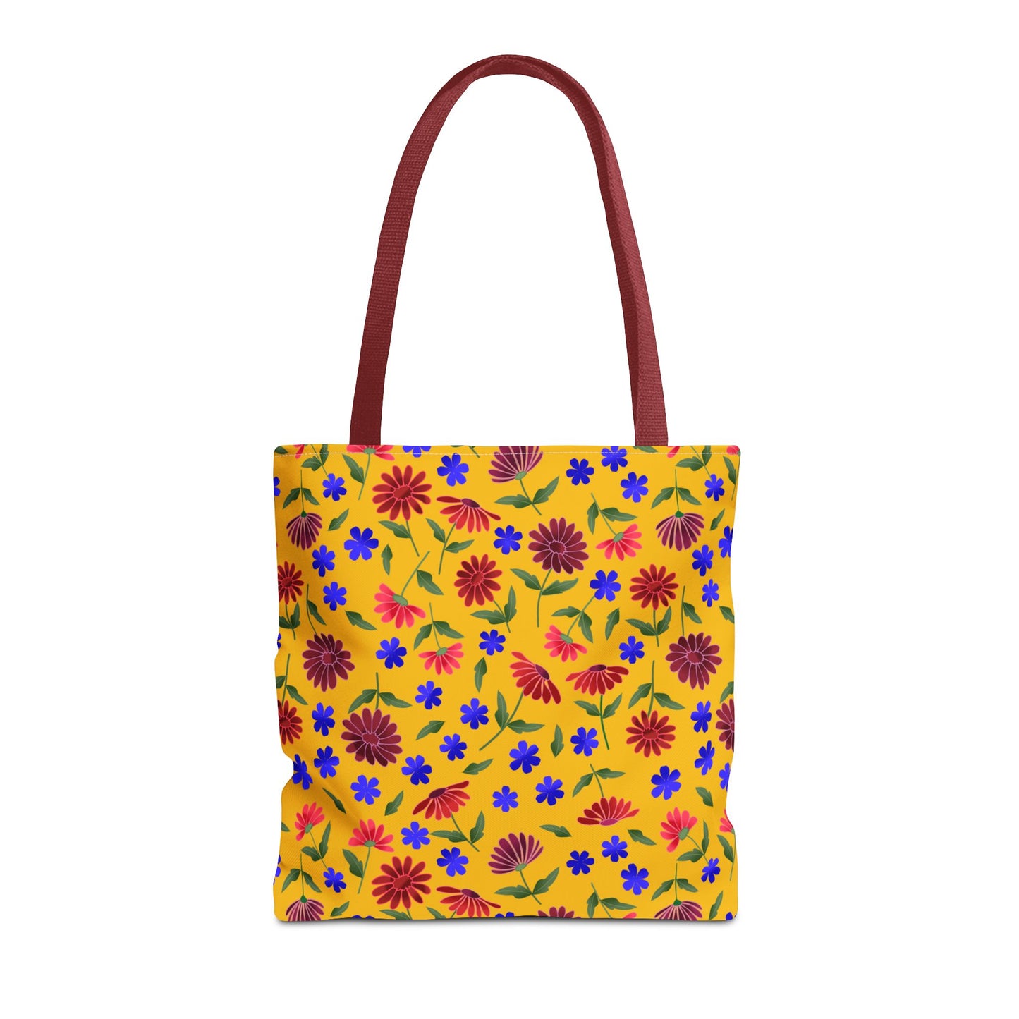 Golden Wildflower Tote Bag features a vibrant mustard-yellow background with red daisies, blue flowers, and green leaves, complemented by durable black handles, offering both style and practicality for daily use.