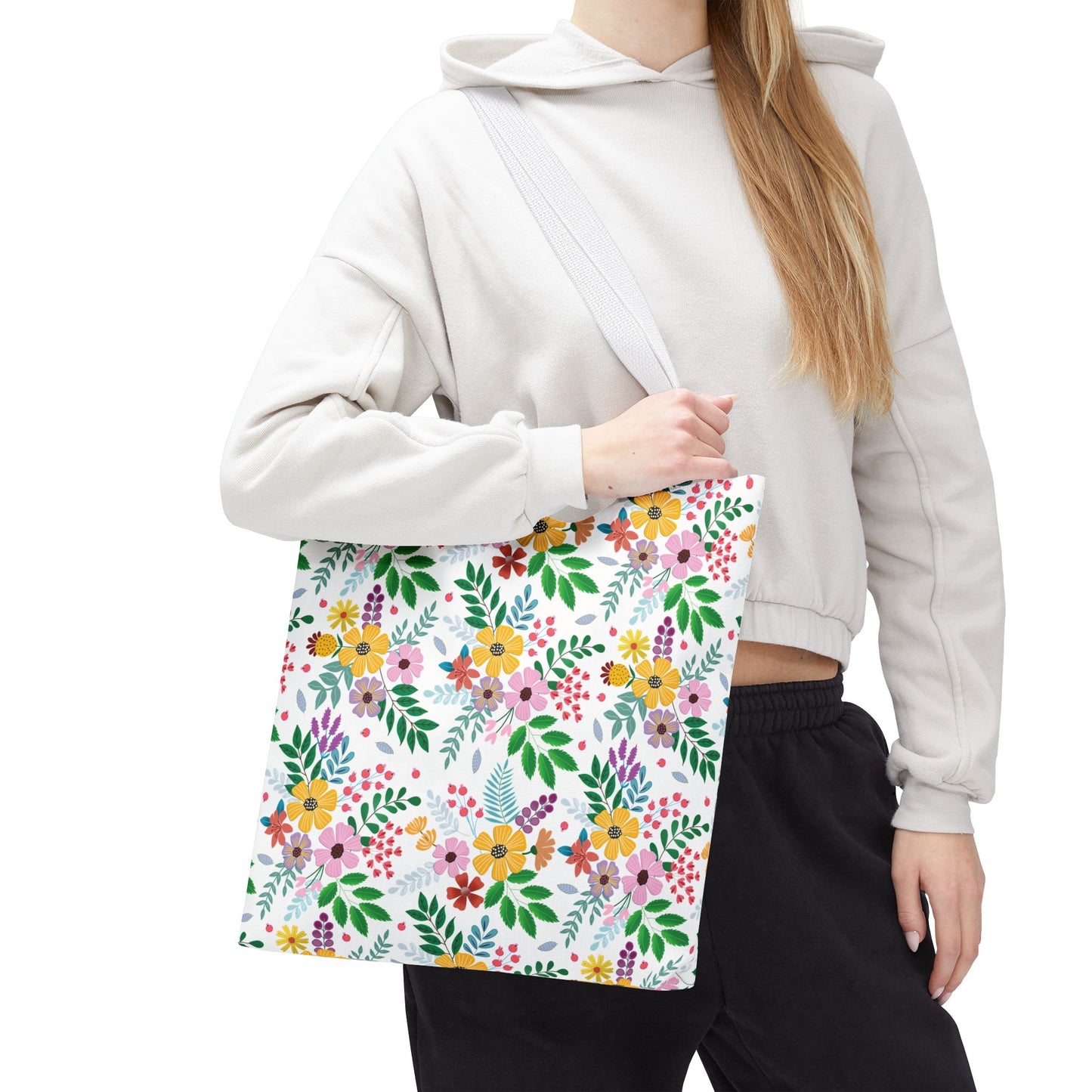 Spring Floral Patch Tote Bag: A person wears a light hoodie and dark pants, holding a large tote with a vibrant floral-and-leaf pattern, perfect for summer outings and beach trips.