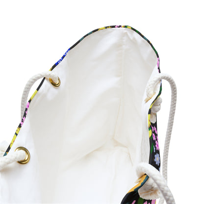 Weekender Bag with braided rope handles, brass grommets, and a floral-trimmed rim. Features a white interior lining, reflecting FireBrook Designs' stylish yet practical approach for travel enthusiasts.