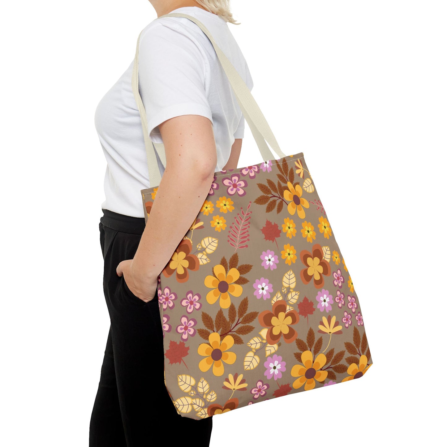 Person wearing casual clothes carries the Harvest Brown Bloom Tote Bag, showcasing its vibrant floral design in autumnal hues, ideal for joyful summer outings.