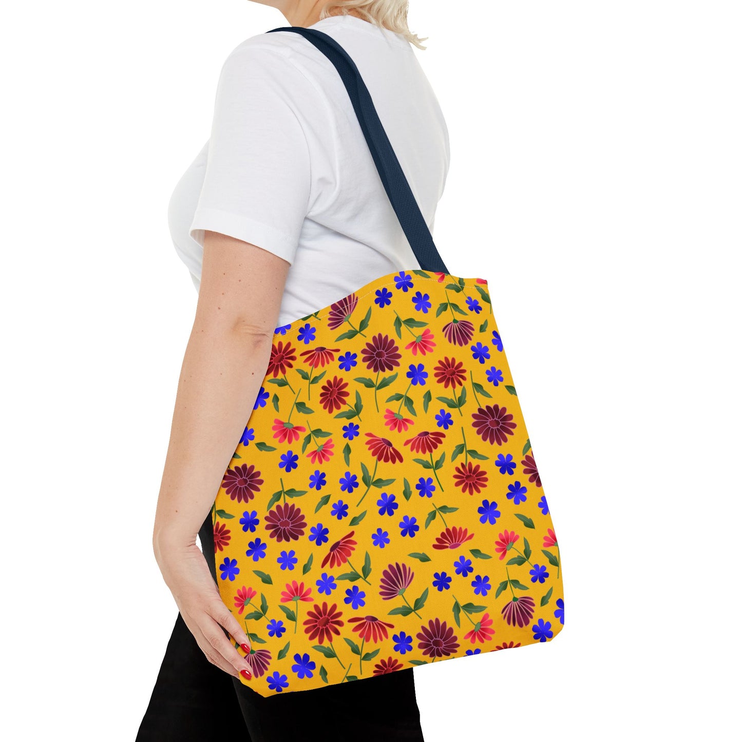 Golden Wildflower Tote Bag with vibrant floral pattern, featuring red and maroon daisies on a mustard-yellow background. Navy blue straps complement the cheerful design, embodying FireBrook Designs' joyful, practical aesthetic.