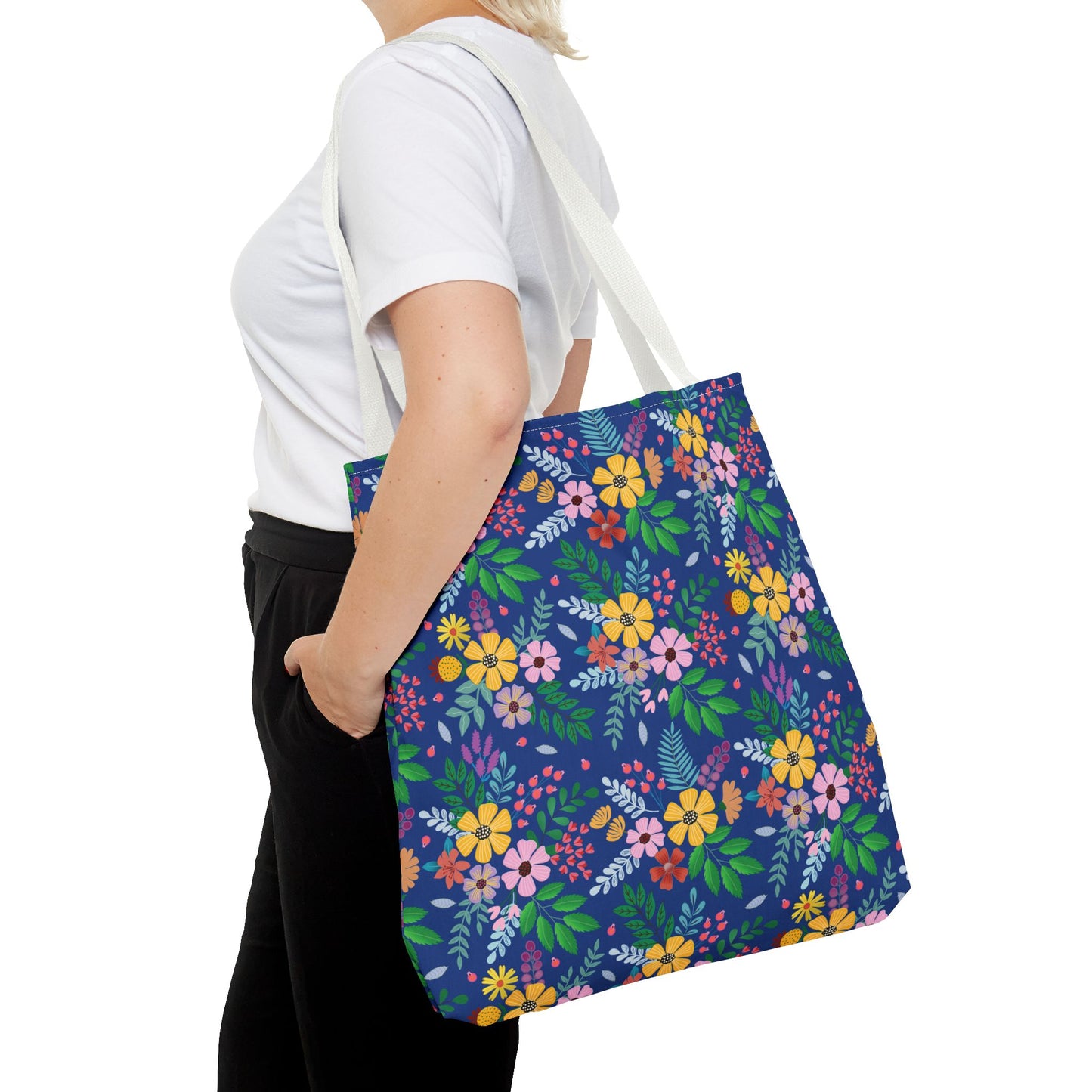 Deep Sea Floral Patch Tote Bag: A large, navy blue canvas tote with vibrant floral patterns, carried over the shoulder. Perfect for summer outings, this durable bag merges style and functionality seamlessly.