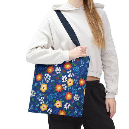 Cornflower Patch Tote Bag featuring a vibrant floral design held by a model. This spacious navy-blue canvas bag is ideal for summer outings, embodying joyful, uplifting style from FireBrook Designs.