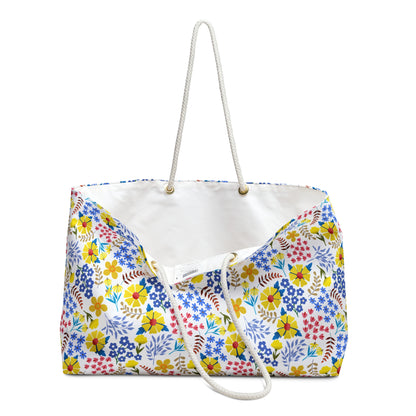 Weekender Bag featuring a vibrant floral print with thick white rope handles through gold-tone grommets, perfect for stylish travel. Unlined interior, spacious design, embodying FireBrook Essentials' joyful and uplifting style.