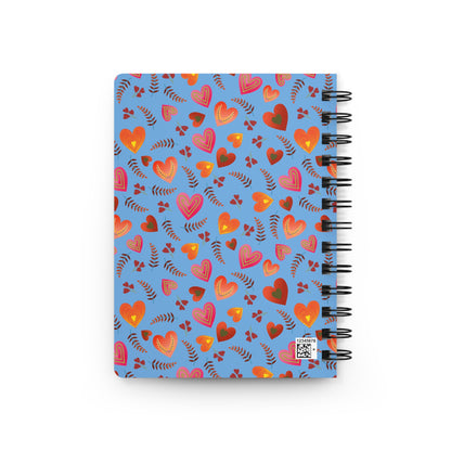 SPIRAL JOURNAL, DURABLE GLOSSY COVER, RULED, 5X7: A bright blue cover adorned with stylized hearts and leaves. Features removable spiral, 150 lined pages, glossy finish. Perfect for joyful, uplifting note-taking.