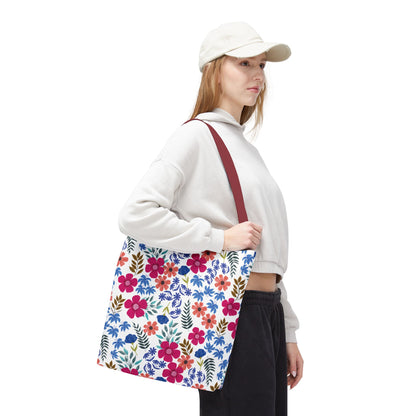 A young woman carries the Floral Tote Bag with a vibrant floral print and burgundy strap, ideal for summer outings. The bag complements her casual look, offering style and functionality.