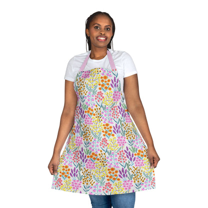 Floral Apron: A model wears a vibrant floral-patterned apron over casual attire, showcasing its knee-length design. Crafted from soft, stain-free polyester, it's perfect for stylish and comfortable kitchen activities.