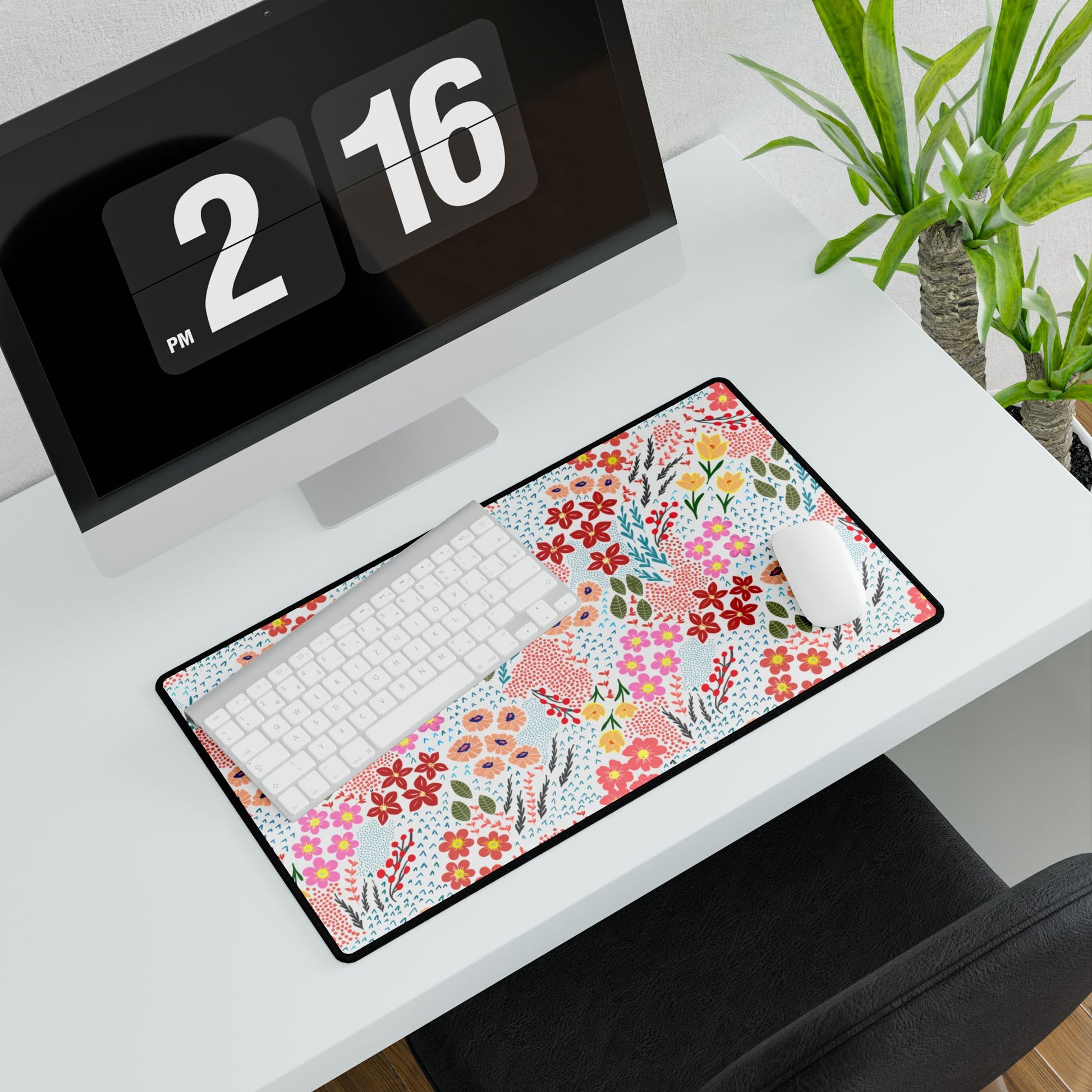 Garden Floral Pattern Desk Mat on a white desk, featuring vibrant floral designs. Positioned beneath a white keyboard and mouse, with a potted plant nearby, enhancing workspace elegance and joy.