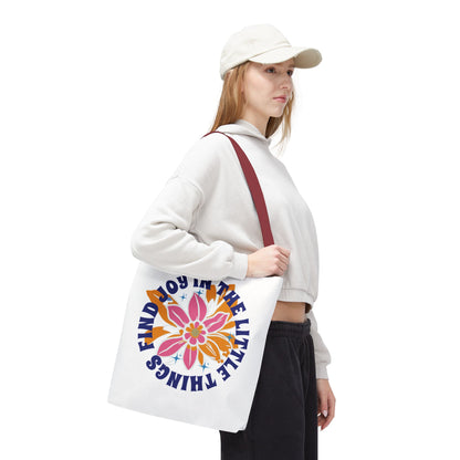 Woman holding a Find Joy in Little Things tote bag, showcasing its durable design and uplifting message, ideal for everyday use.