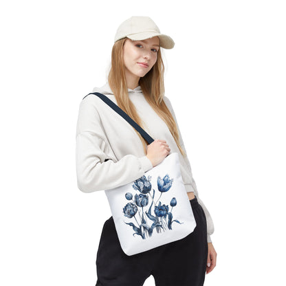 Woman wearing a hat holds a Flowers in Blue Hue watercolor tote bag, showcasing its floral design and functionality.
