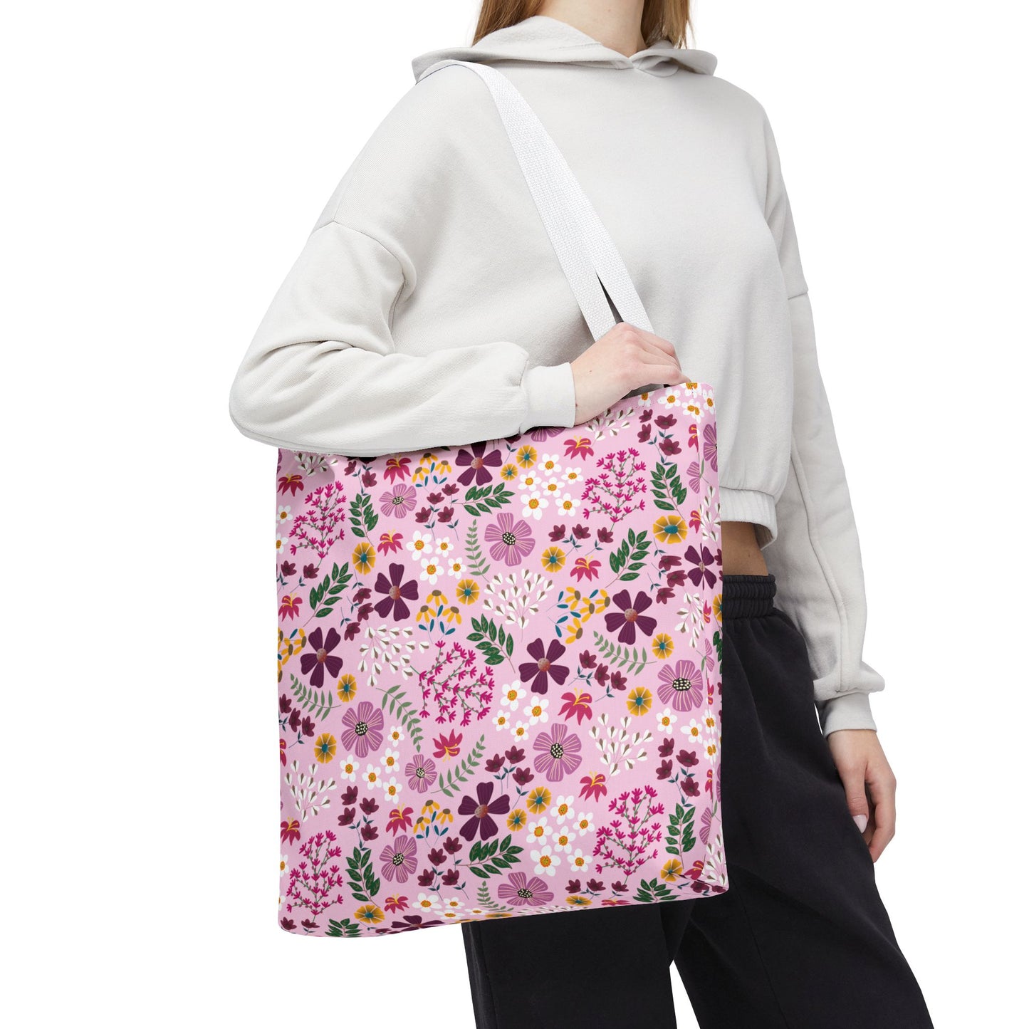 Floral Tote Bag: A person carries an oversized tote with a vibrant floral design, featuring magenta, purple, yellow, and white flowers on a pale pink background, embodying FireBrook Designs’ stylish and joyful aesthetic.