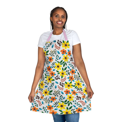 A woman models the Floral Apron, featuring vibrant yellow and orange flowers with green leaves. Made from polyester canvas, it’s stain-free, offering stylish protection for cooking and crafting.
