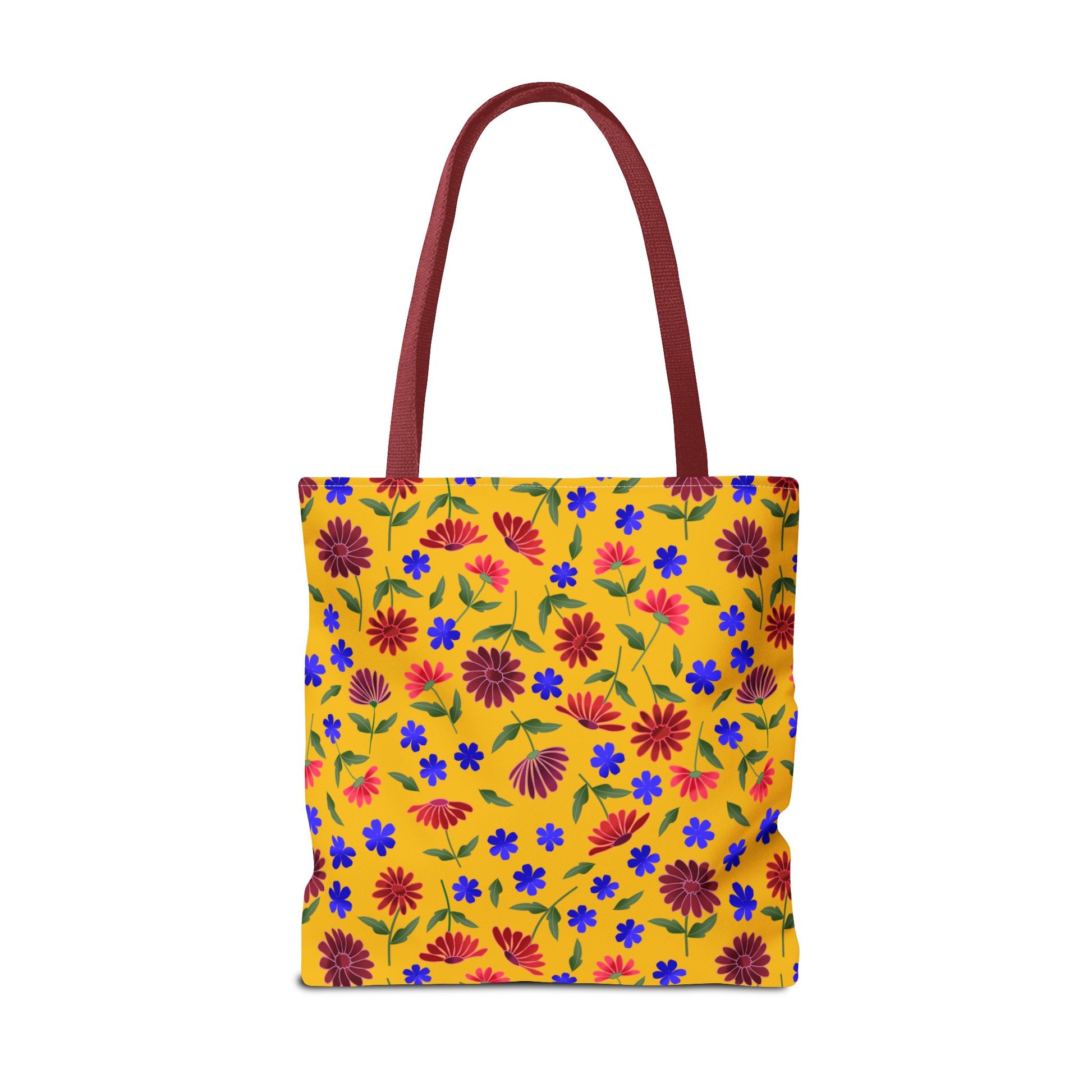 Golden Wildflower Tote Bag featuring a warm golden-yellow canvas with vibrant red and pink daisies, small blue flowers, and green leaves; deep reddish-maroon handles add a stylish, durable touch.