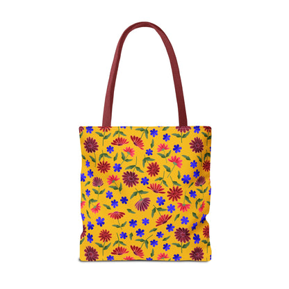 Golden Wildflower Tote Bag featuring a warm golden-yellow canvas with vibrant red and pink daisies, small blue flowers, and green leaves; deep reddish-maroon handles add a stylish, durable touch.